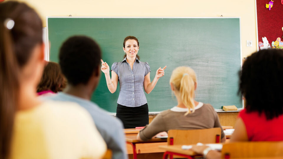 Lehrerin vor grüner Tafel